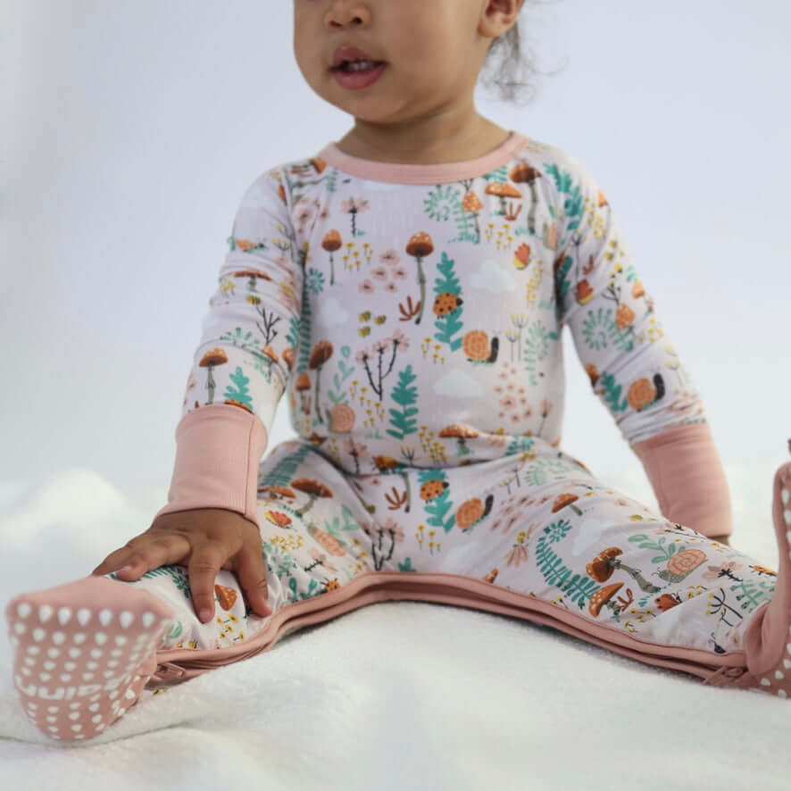 Toddler wearing Bamboo Crescent Zipp Jammies with a woodland fern pattern.