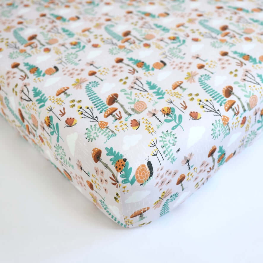 Bamboo Baby Crib Sheet featuring a whimsical fern and woodland print with snails, ladybugs, and butterflies for a calming nursery.