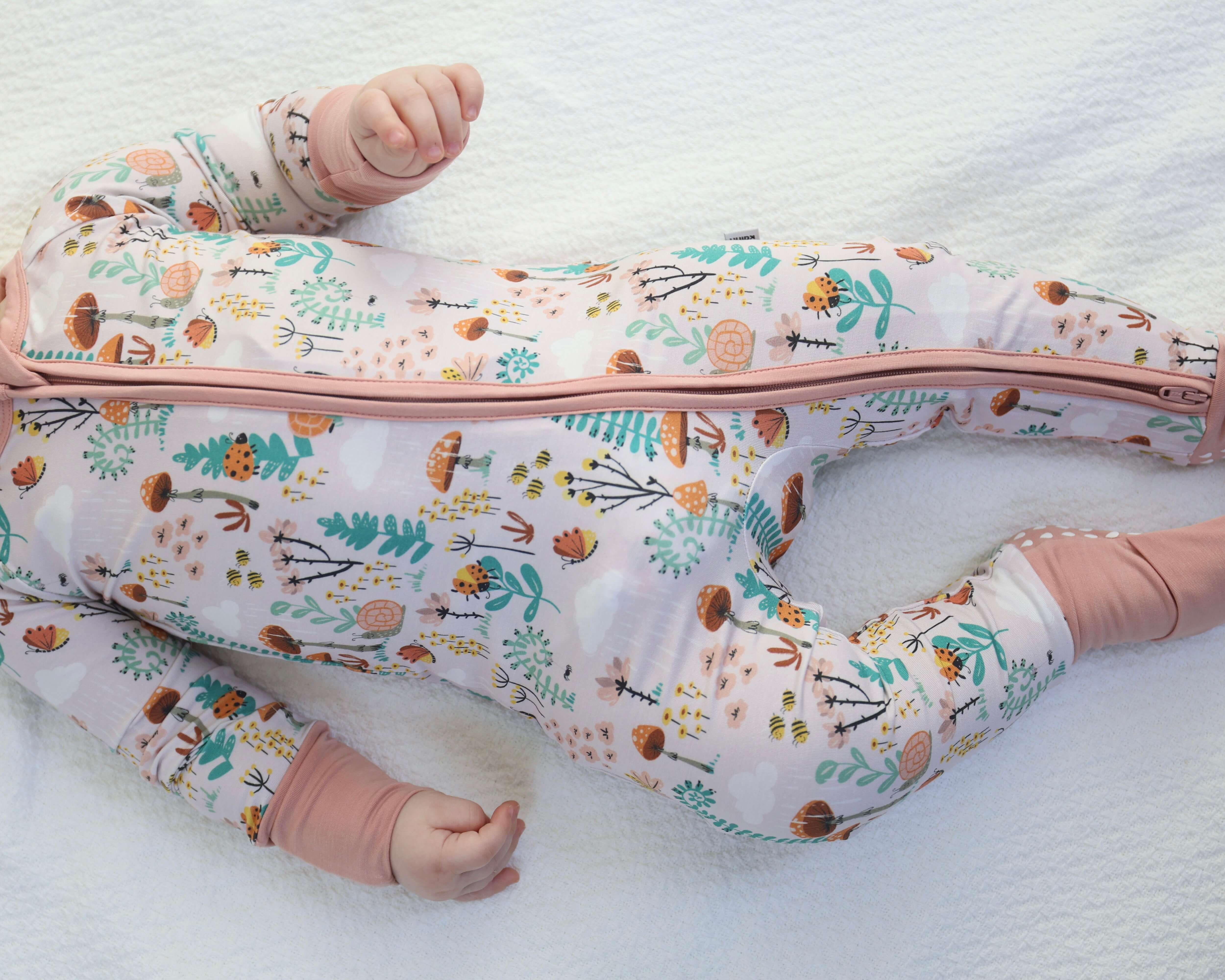 Baby wearing Bamboo Zipp Jammies in fern print, featuring a zippered front and soft fabric for ultimate comfort.