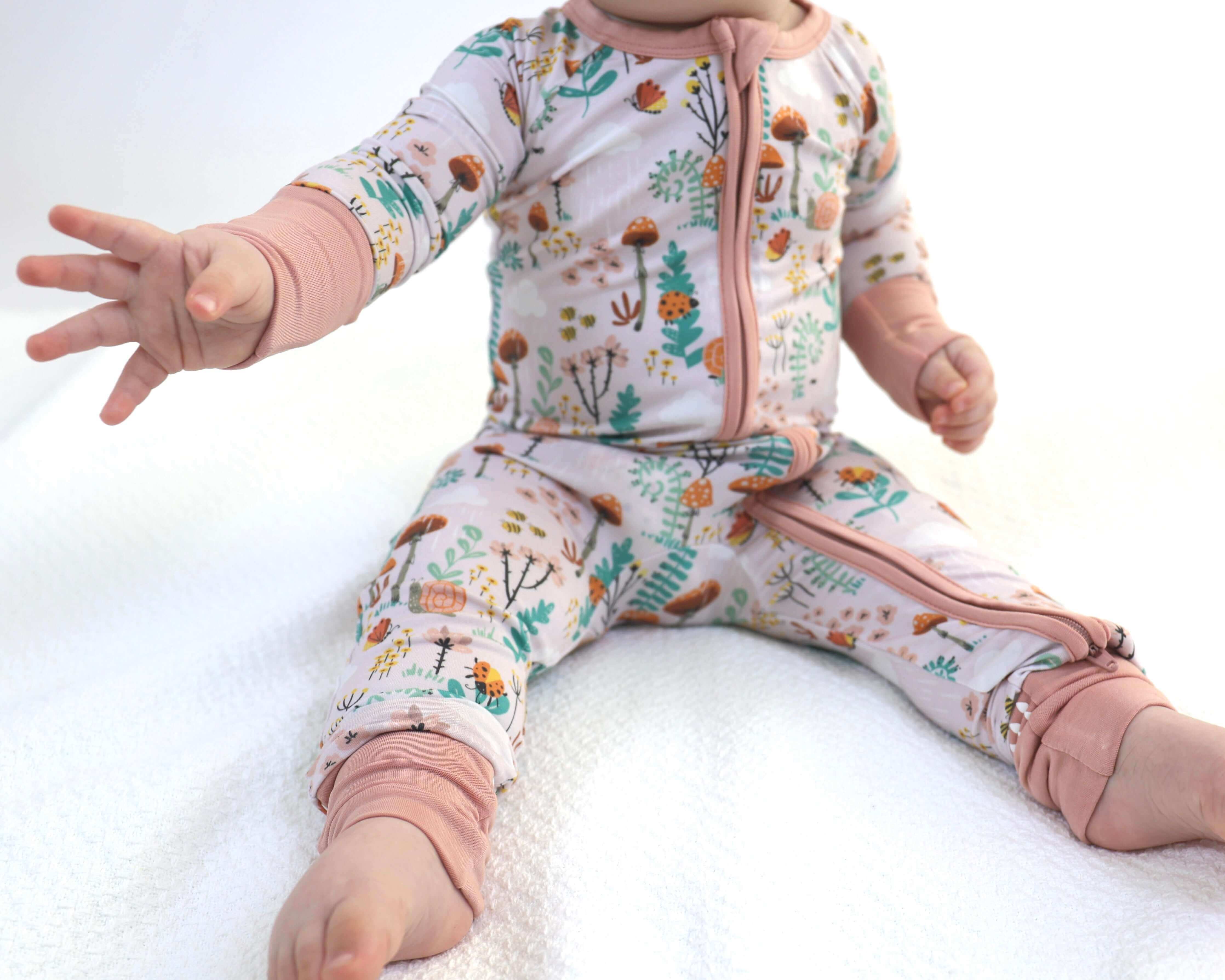Baby wearing Bamboo Zipp Jammies with fern and forest prints, showcasing soft and breathable fabric.