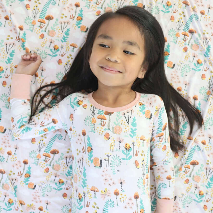 Smiling child in cozy Fern print jammies, showcasing soft, breathable, eco-friendly bamboo fabric.