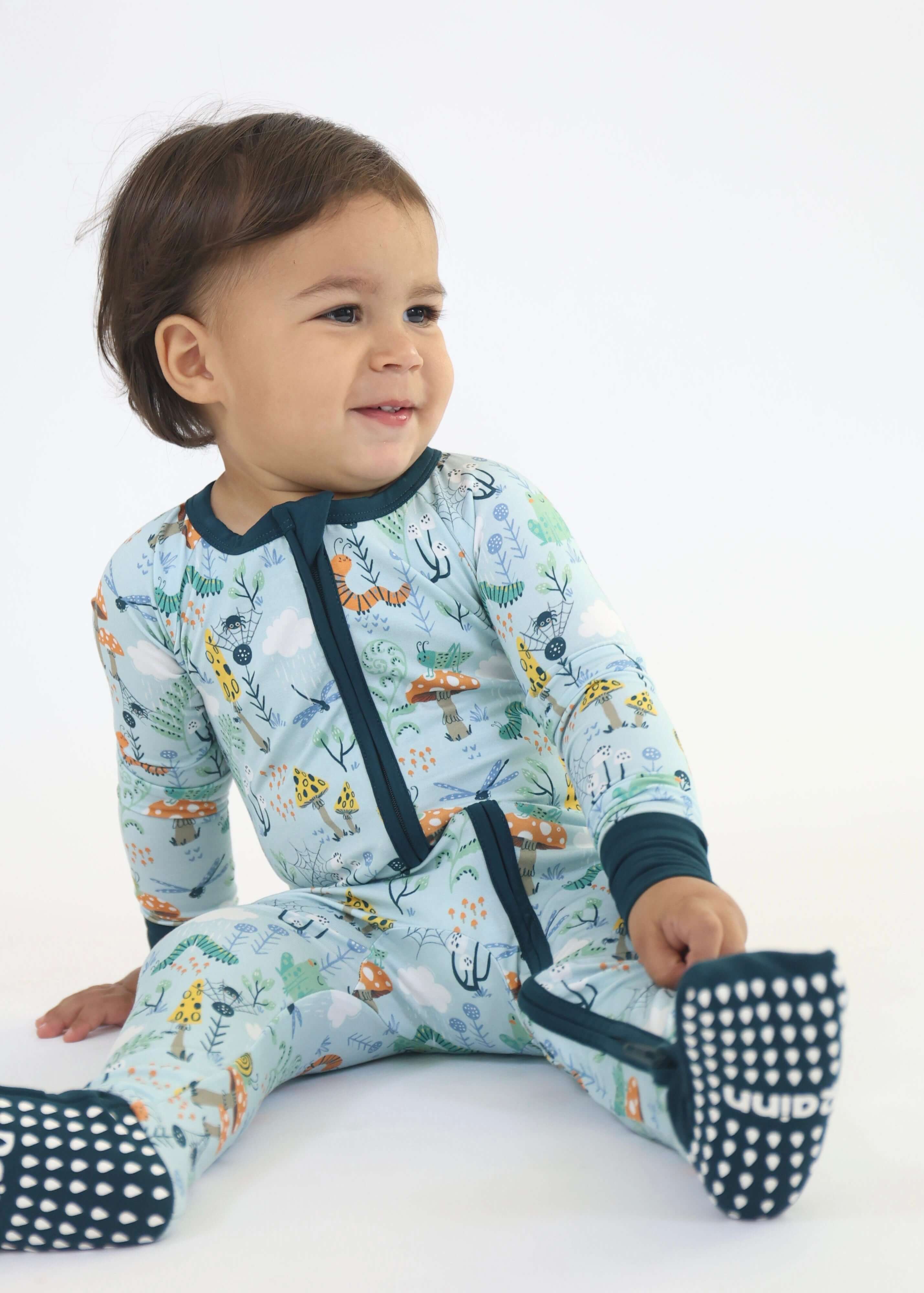 Child wearing Bamboo Zipp Jammies with Critter Hollow design featuring woodland animals, whimsical frogs, and lively nature patterns.