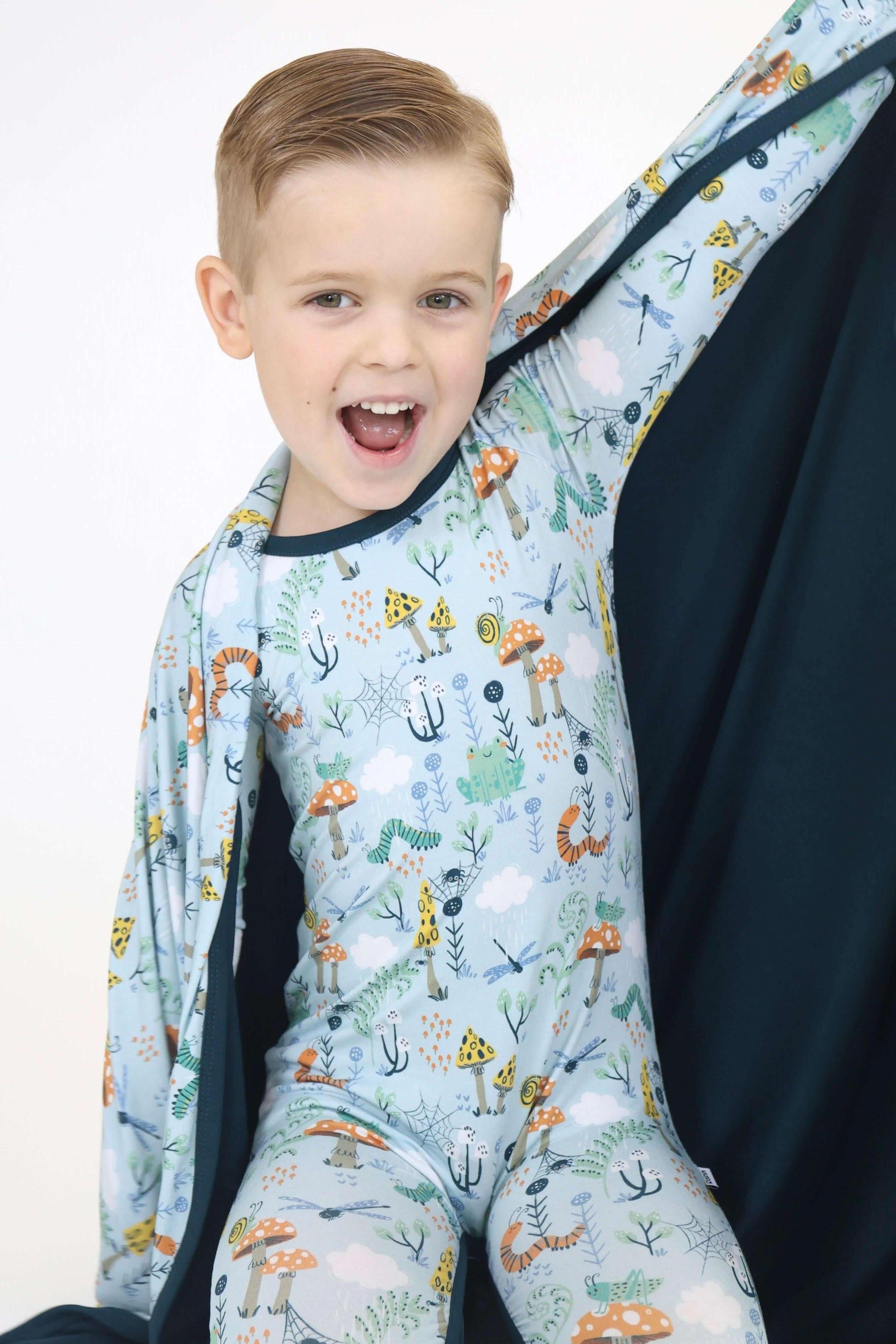 Joyful child in Critter Hollow Rainn Cozy Blanket, showcasing fun prints and cuddly comfort for cozy moments.