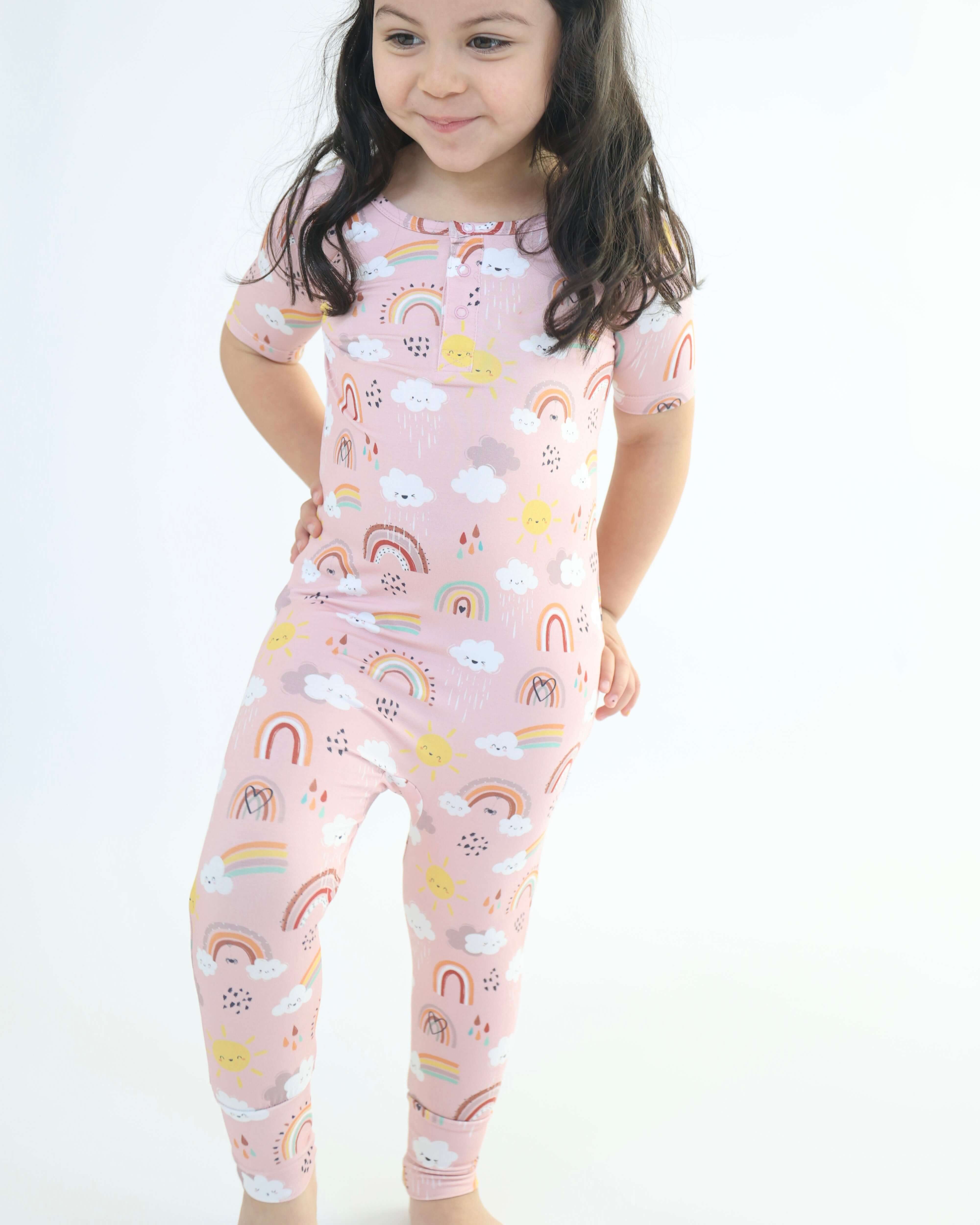 Adorable child in Rainnbow pull-up romper with clouds and rainbows, showcasing eco-friendly bamboo fabric.