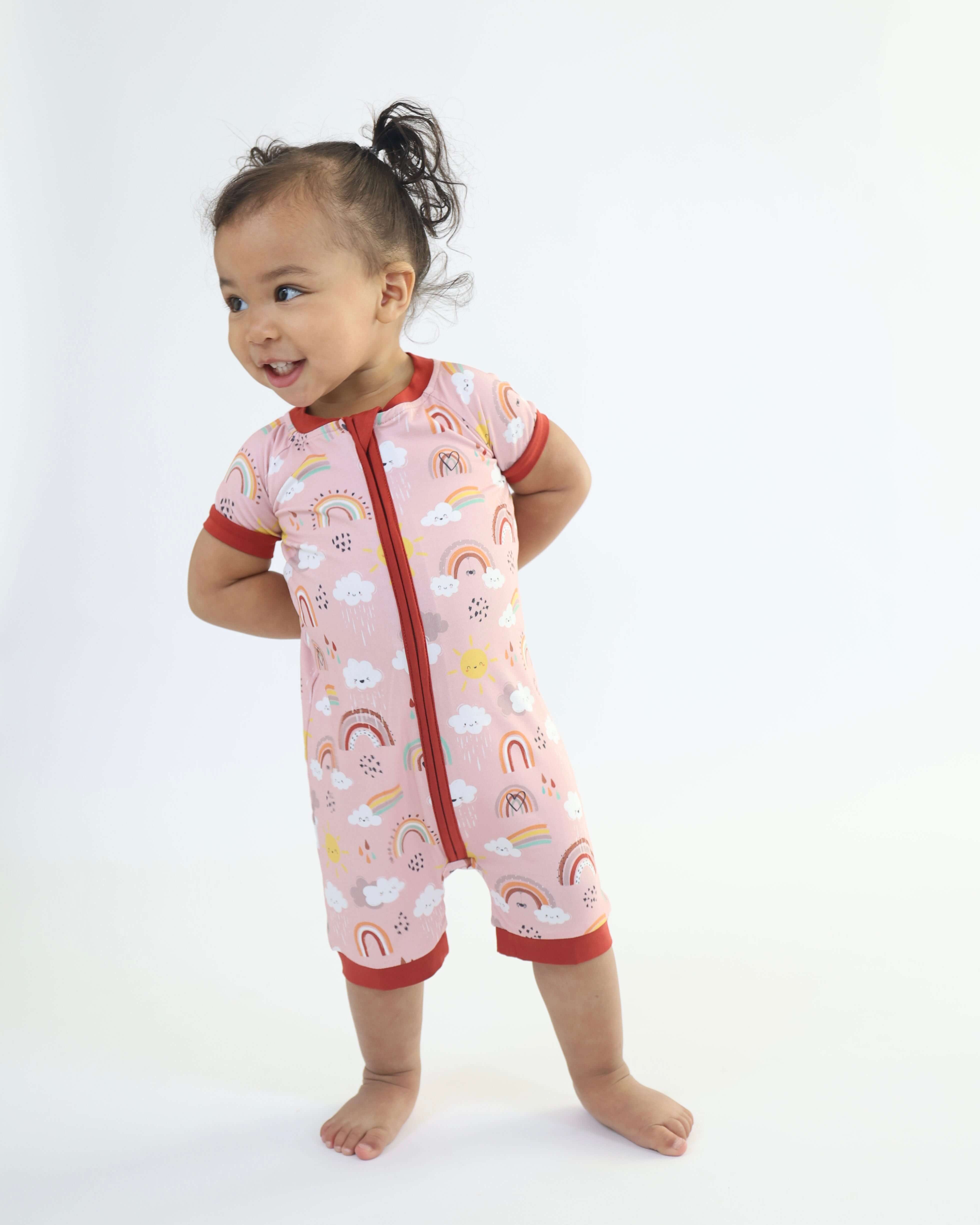 Baby wearing a Rainnbow short zipp romper with rainbow prints, perfect for playful and cozy moments.